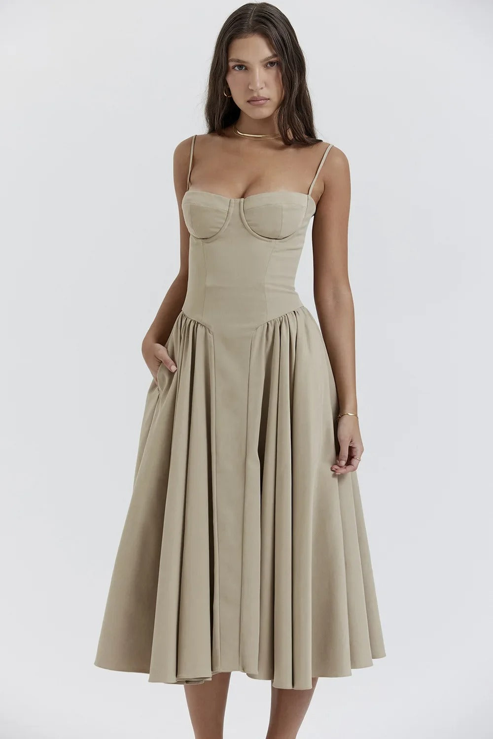 Elegant midi pleated dress by Montaracrest featuring a structured bodice and side pockets, displayed on a model.