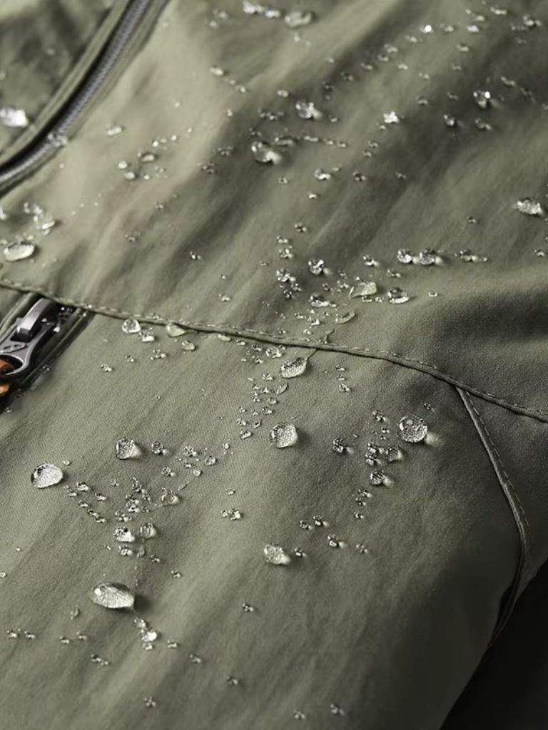 Montaracrest tactical waterproof jacket for expeditions, shown in dark color with hood and multiple pockets.