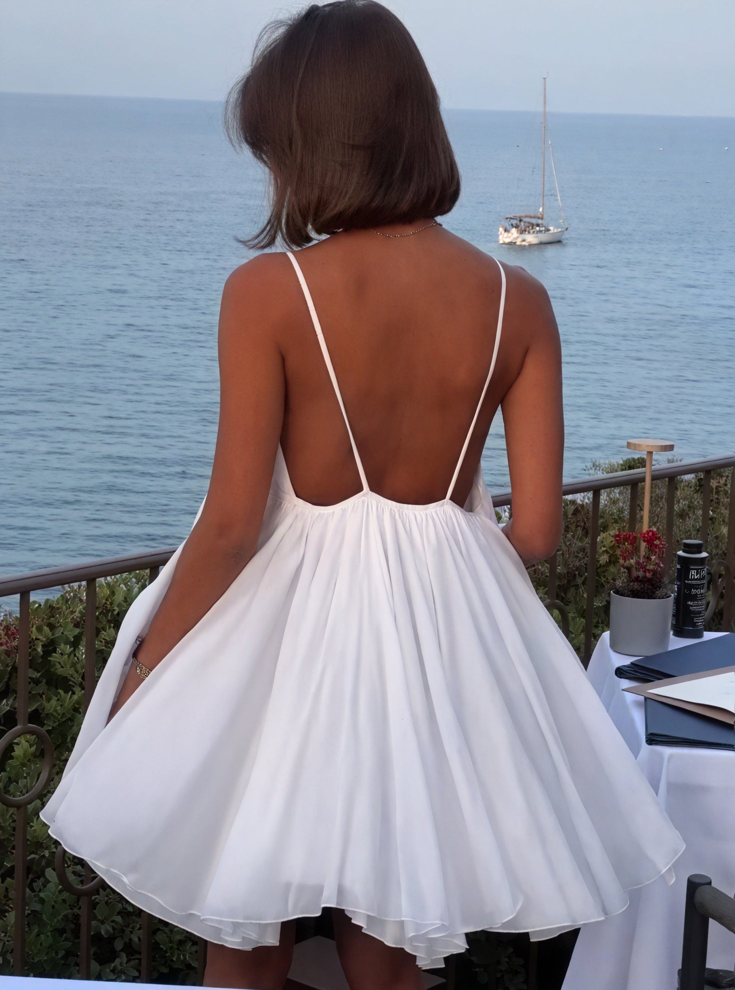Lightweight fluid dress with thin straps and V-neckline by Montaracrest, shown on a model in a casual setting.