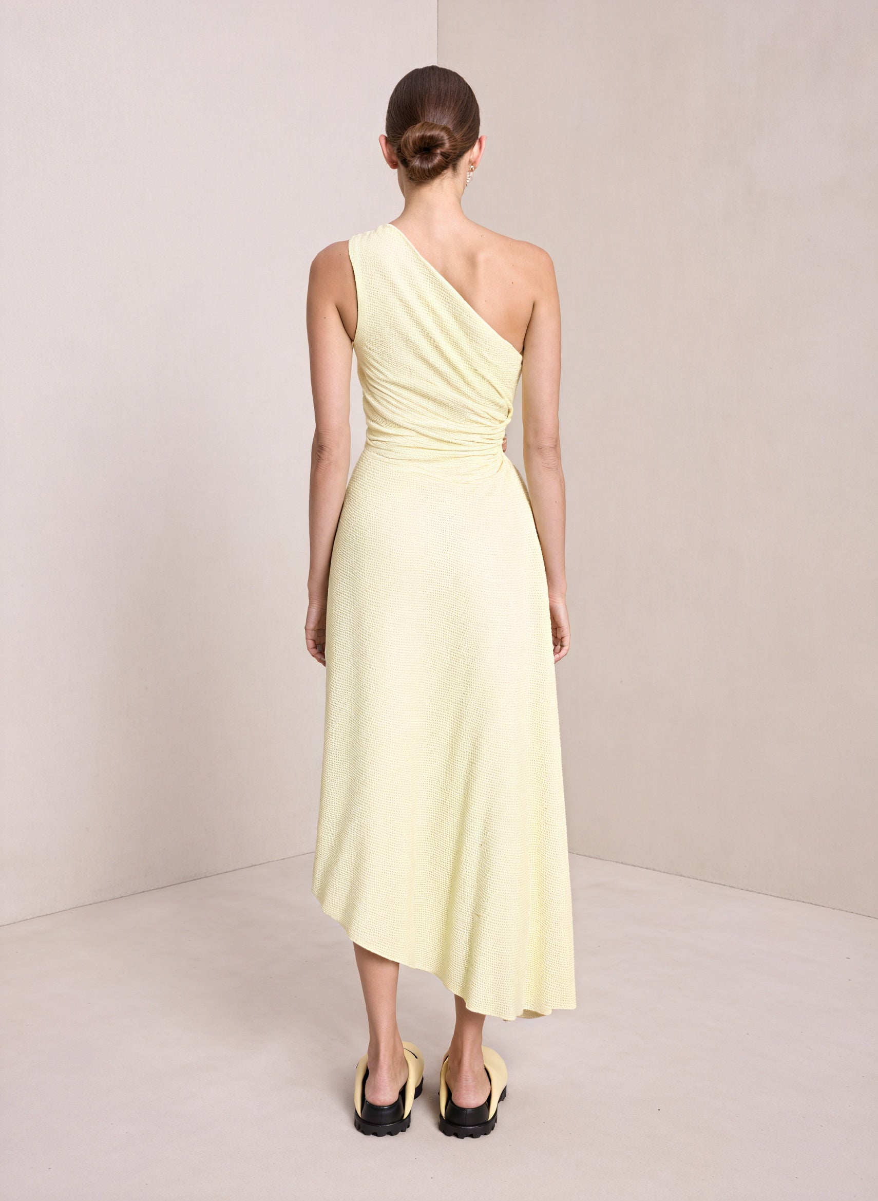 Light pink one-shoulder pleated dress with asymmetrical hem from Montaracrest, showcasing elegant fabric and stylish design.