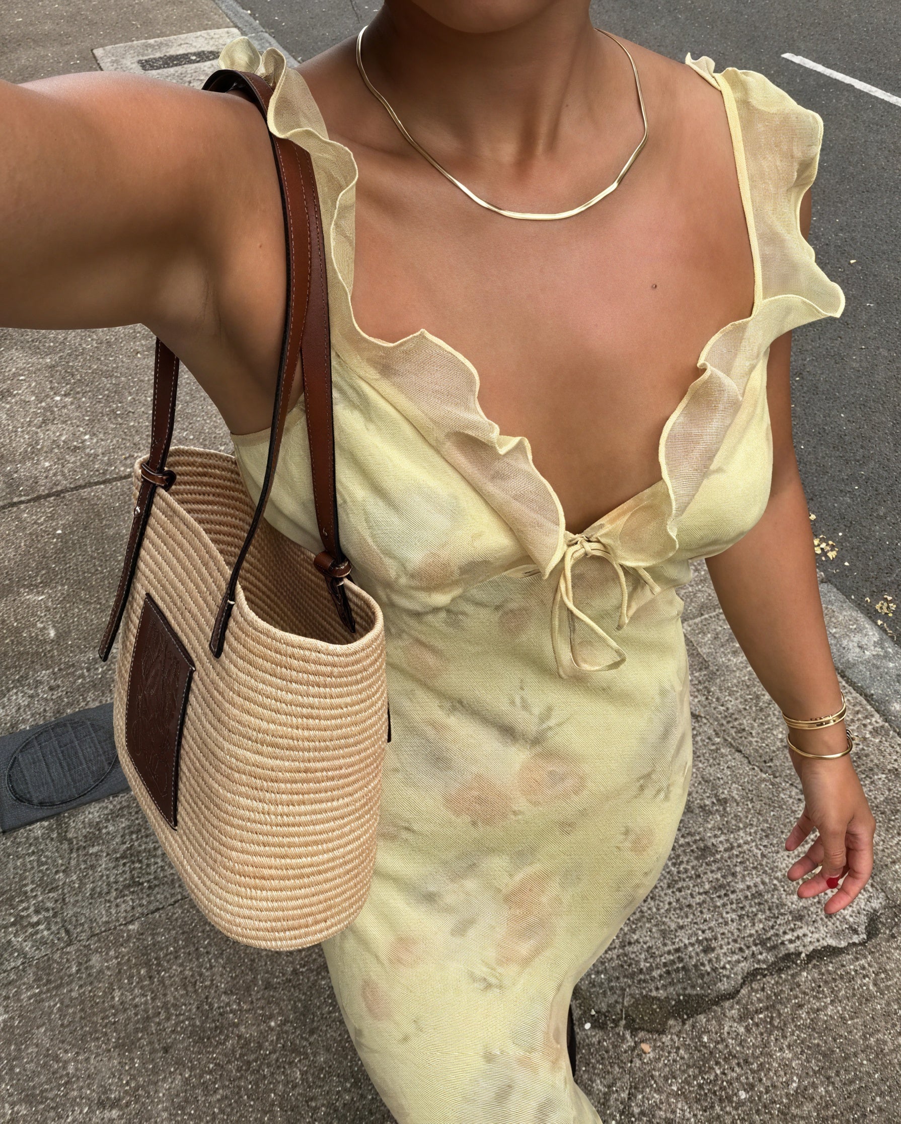 Floral dress with thin shoulder straps and ruffle details by Montaracrest, displayed on a hanger.